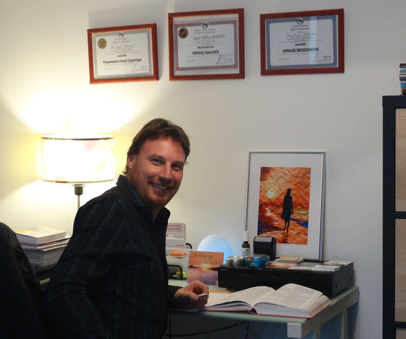 Jean-Charles Bernard, hypnothérapeute, à son bureau devant ses diplômes de l'IFHE